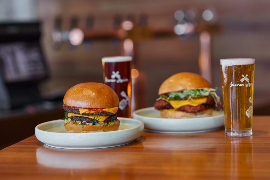 two burgers on plates served in the brewhouse